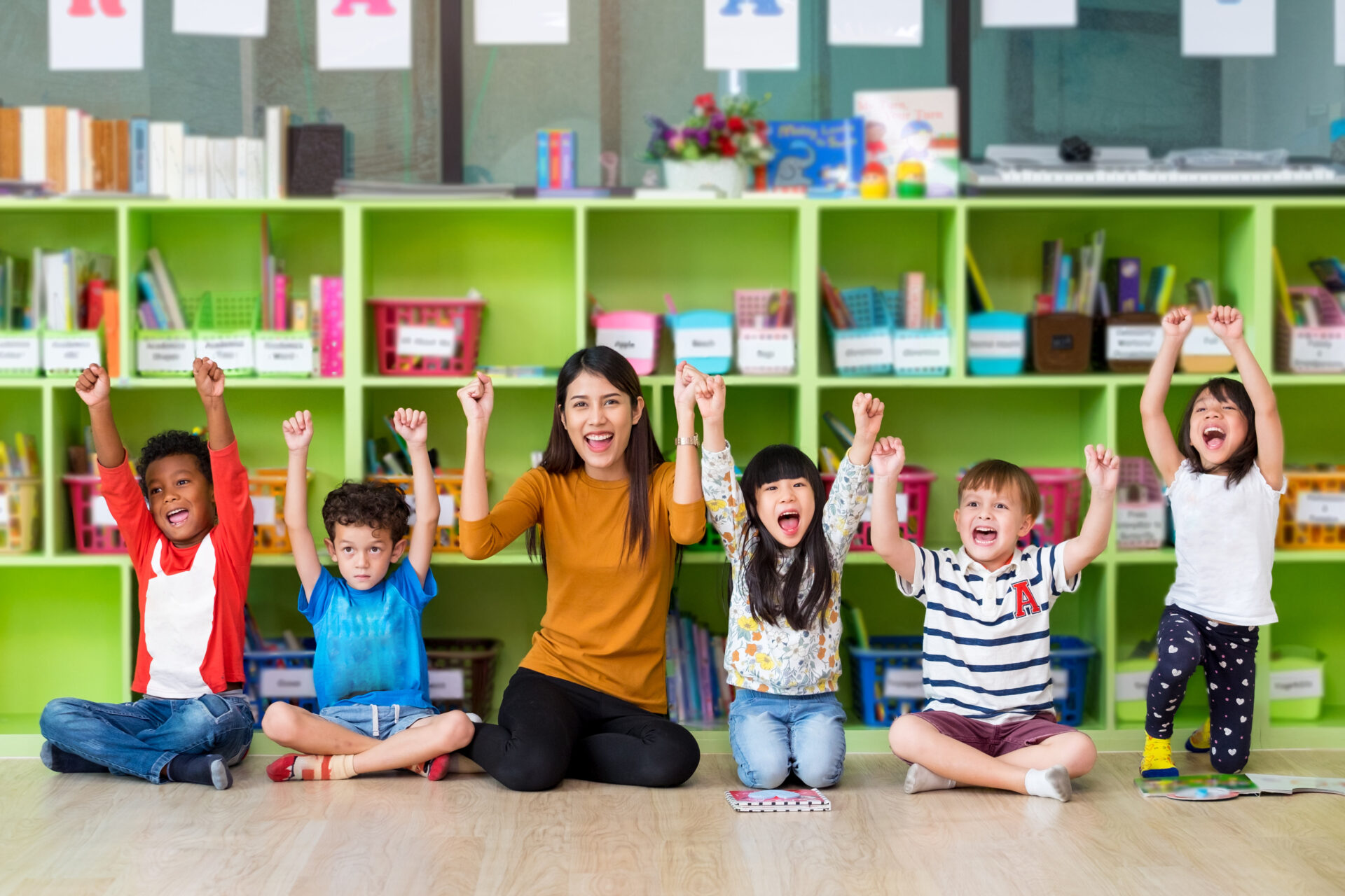 Happy Asian female teacher and mixed race kids in classroom,Kindergarten pre school concept